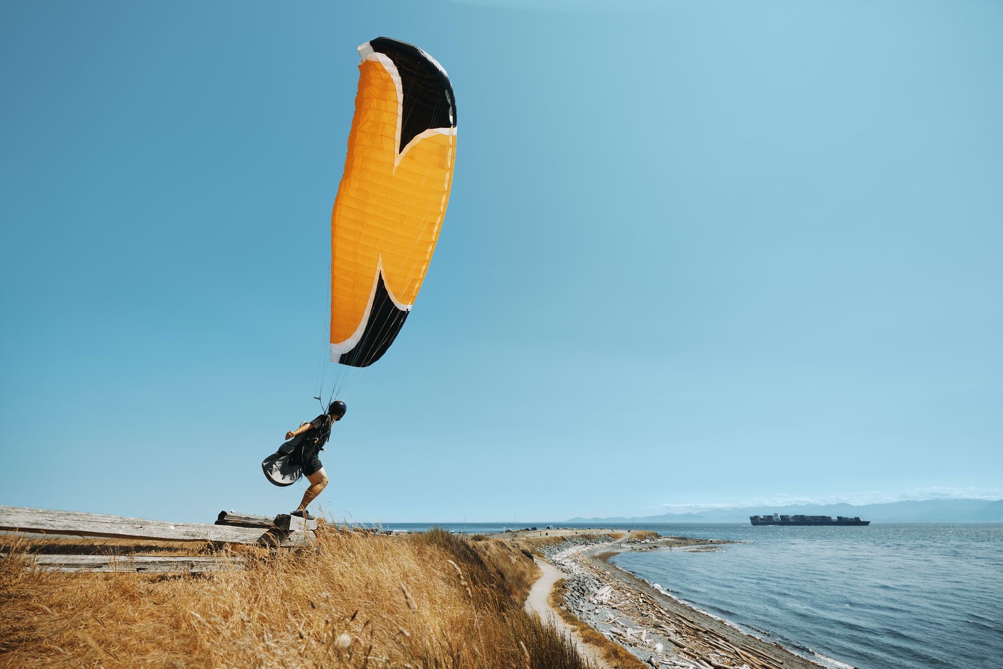 paraglider-paraglider-standing-on-the-edge-of-pacific-ocean-cliff-oceanview-.jpg